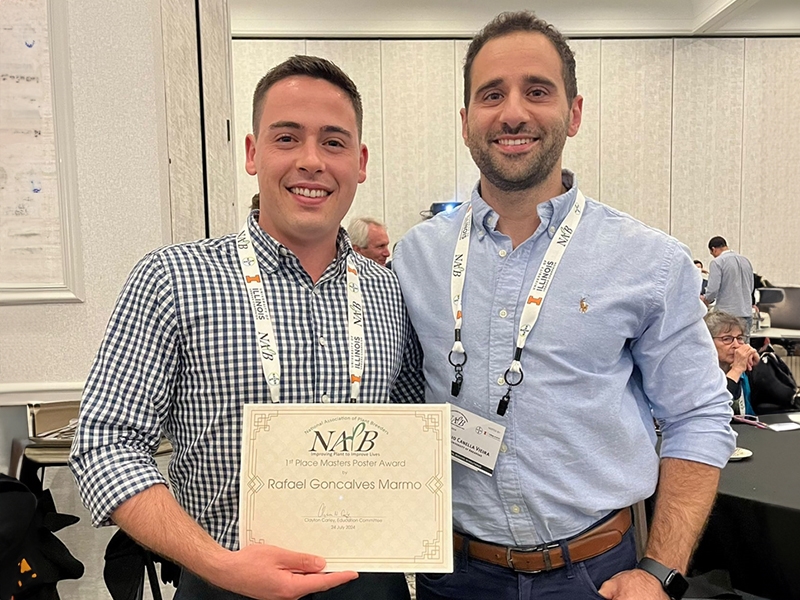 Rafael Marmo holding his award with advisor Dr. Caio Canella Vieira beside him.