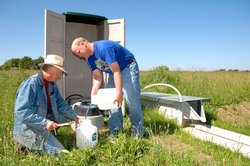 Tommy Daniel, University of Arkansas professor of crop, soil and environmental sciences, left, and research assistant Paul DeLaune collect water samples from a field test in a project to develop the phosphorus index for the Eucha-Spavinaw watershed.